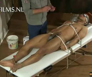 Vastgebonden en geblinddoekt ligt een donkere jongen op de massagetafel te wachten op wat komen gaat. De masseur laat de massage achterwege en begint hem gelijkt te pijpen. Hardcore , Masseur pijpt negerlul van vastgebonden jongen 