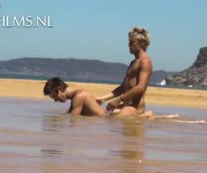 en ung, slank homoseksuelle par på nudiststrand og efter en tur på stranden, de finde et roligt sted. brunette går på knæ i vandet og tager hans blonde kæreste cock i sin mund. han slikker, suger hans pik og som en belønning wo