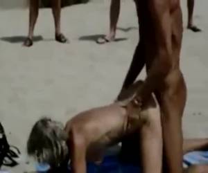 Als een geile teef geneukt voor publiek. Op een vol strand word ze hard op zijn hondjes genomen tot ze het uit schreeuwt tijdens een overweldigend orgasme. Als een geile teef geneukt voor publiek op een vol strand 